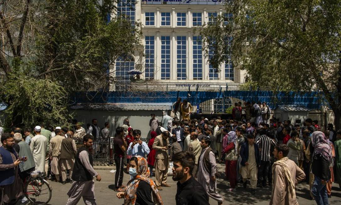 Afegãos fazem fila em frente à sede do banco Azizi, em Cabul, no mesmo dia em que Talibã tomou o poder Foto: JIM HUYLEBROEK / NYT