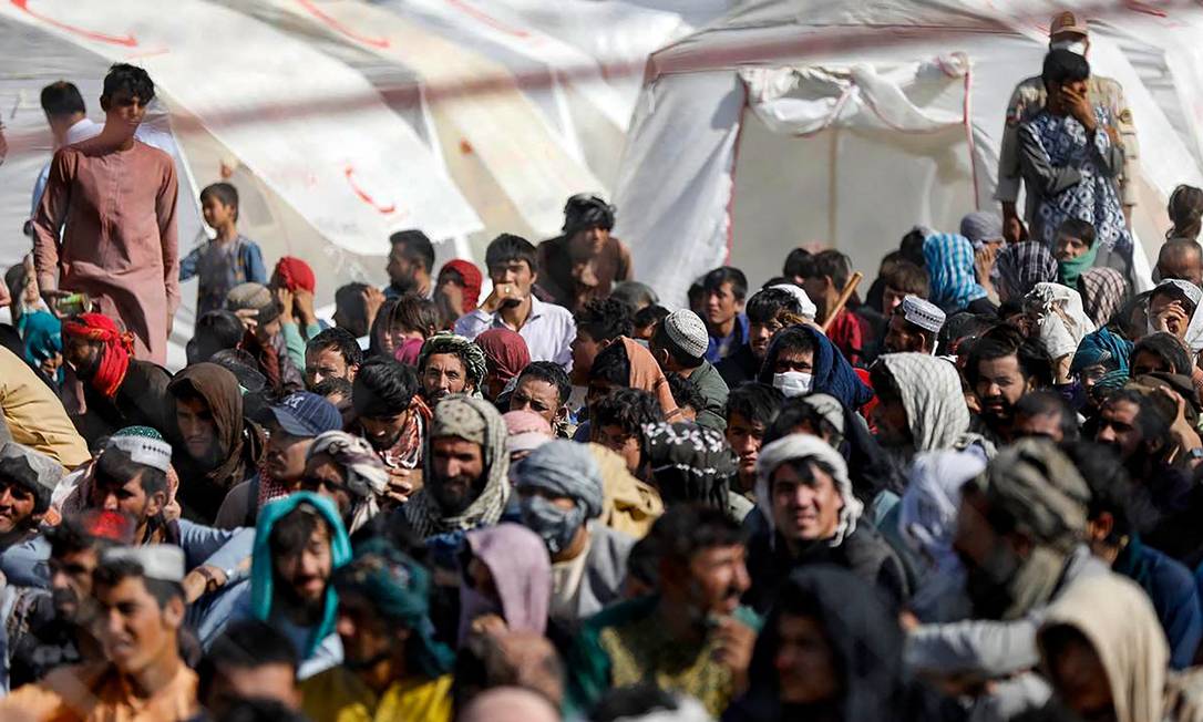 Refugiados afegãos aguardam na fronteira do Afeganistão com o Irã, após fugirem do Talibã Foto: MOHAMMAD JAVADZADEH / AFP/19-08-2021