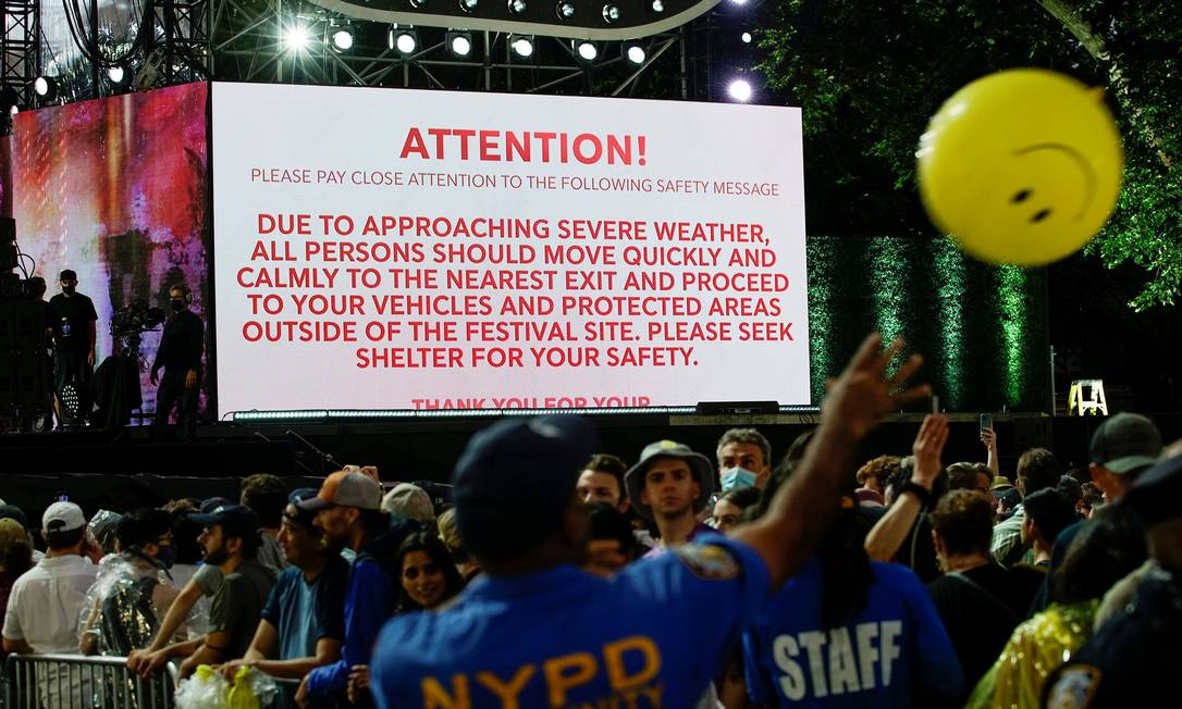 Tela mostra informações sobre mau tempo se aproximando da área enquanto policiais tentam evacuar gramado do Central Park após cancelamento do concerto de boas-vindas Foto: EDUARDO MUNOZ / REUTERS/21-08-2021
