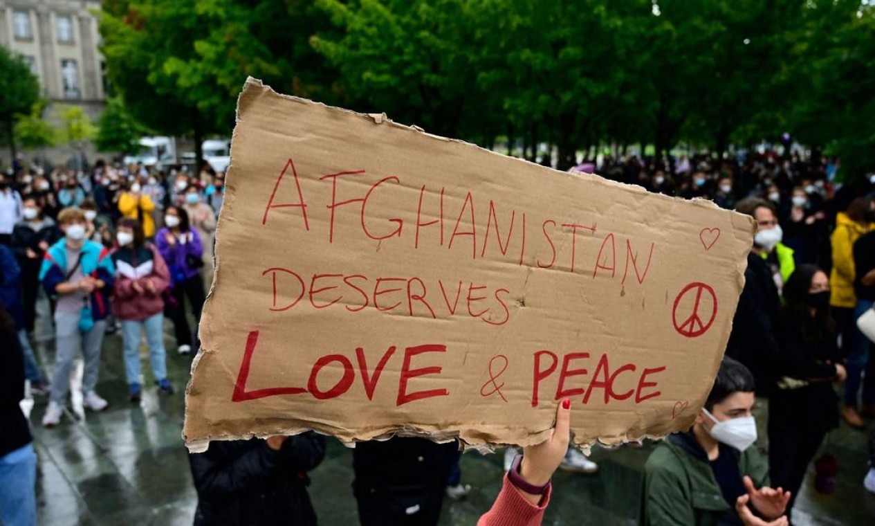 Manifestante segura um cartaz com os dizeres "O Afeganistão merece amor e paz" durante ato perto da Chancelaria, em Berlim Foto: JOHN MACDOUGALL / AFP