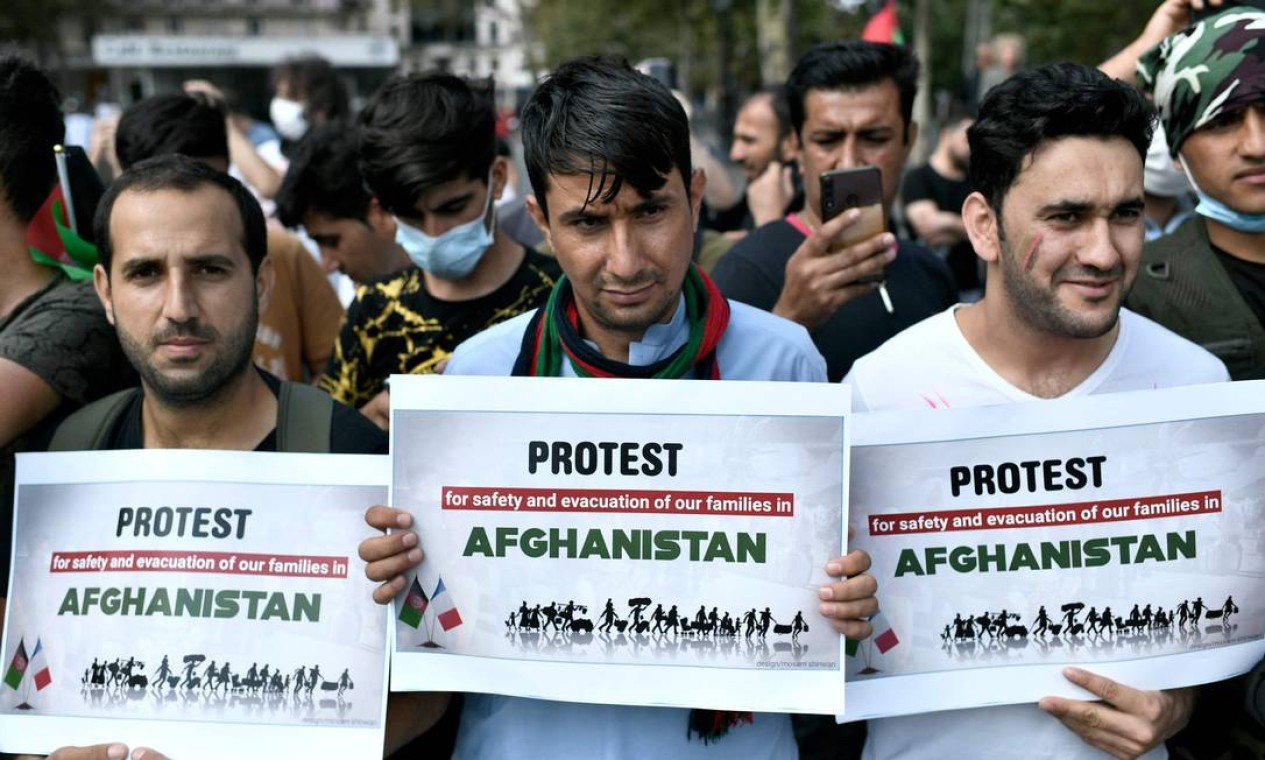 Manifestantes seguram cartazes durante uma manifestação em apoio ao Afeganistão após a tomada do país pelo Talibã, na Place de la Republique em Paris Foto: STEPHANE DE SAKUTIN / AFP