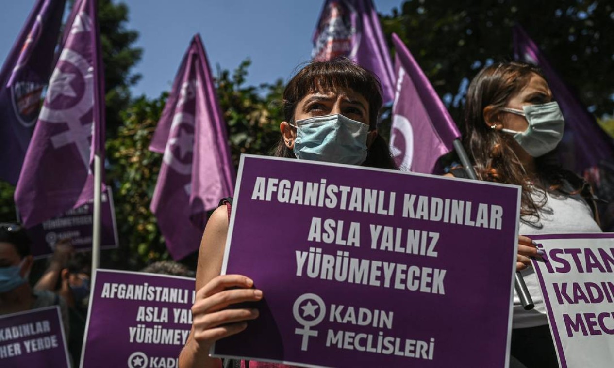 Em Istambul, na Turquia, mulheres exibem cartazes com a frase "Mulheres afegãs nunca caminharão sozinhas", em frente ao consulado do Afeganistão na capital Foto: OZAN KOSE / AFP