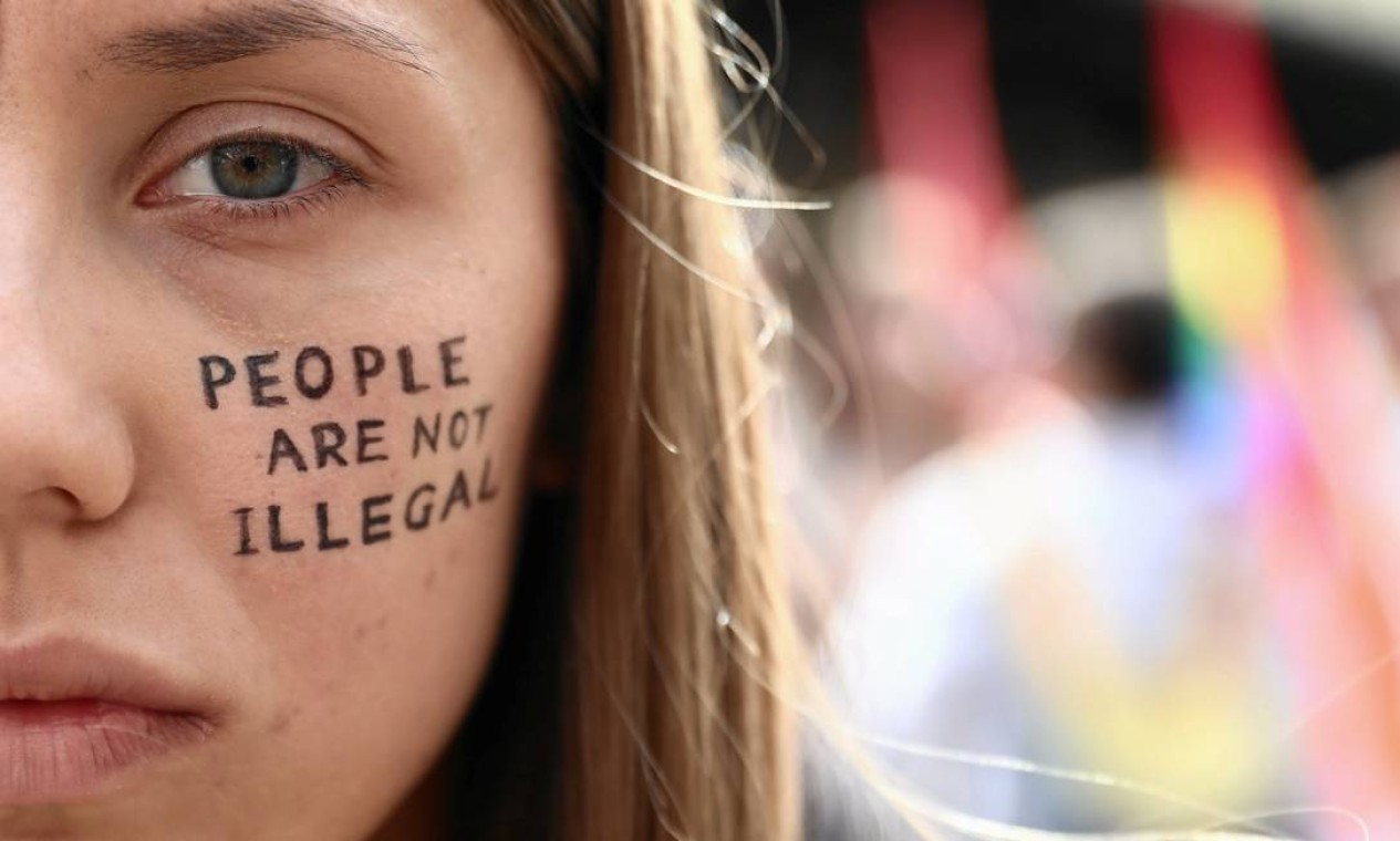 Mulher tem pintada no rosto a mensagem "pessoas não são ilegais" durante manifestação de solidariedade ao povo do Afeganistão, em Cracóvia, Polônia Foto: JAKUB PORZYCKI / Agencja Gazeta via REUTERS