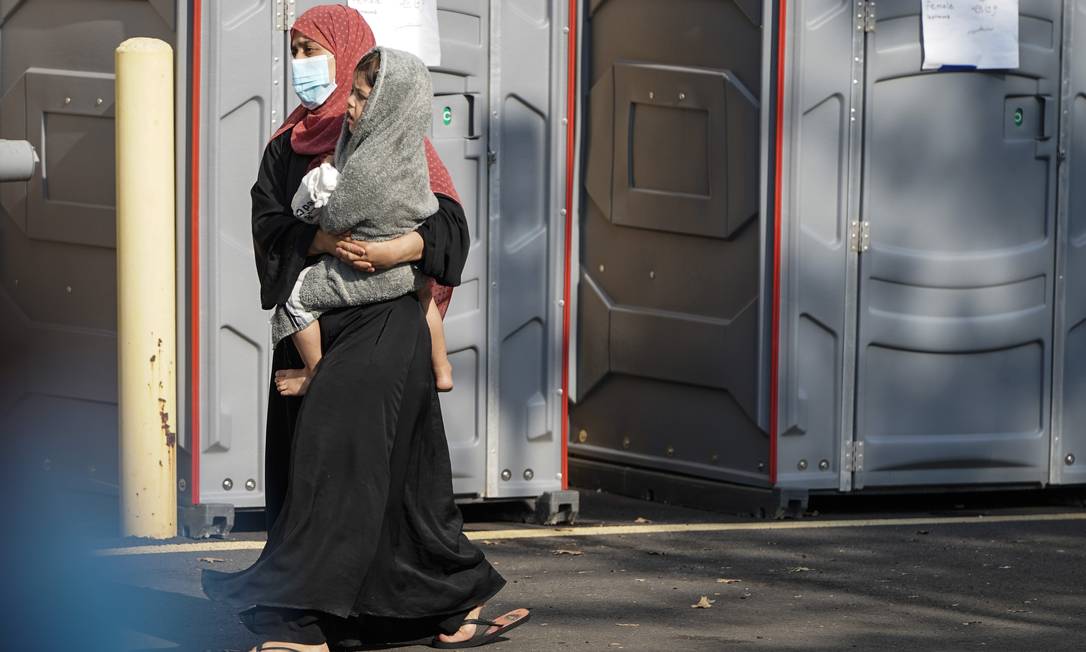 Uma mulher carrega uma criança em um centro de processamento para refugiados removidos do Afeganistão no Dulles Expo Center em 24 de agosto de 2021 em Chantilly, Virgínia Foto: JOSHUA ROBERTS / AFP