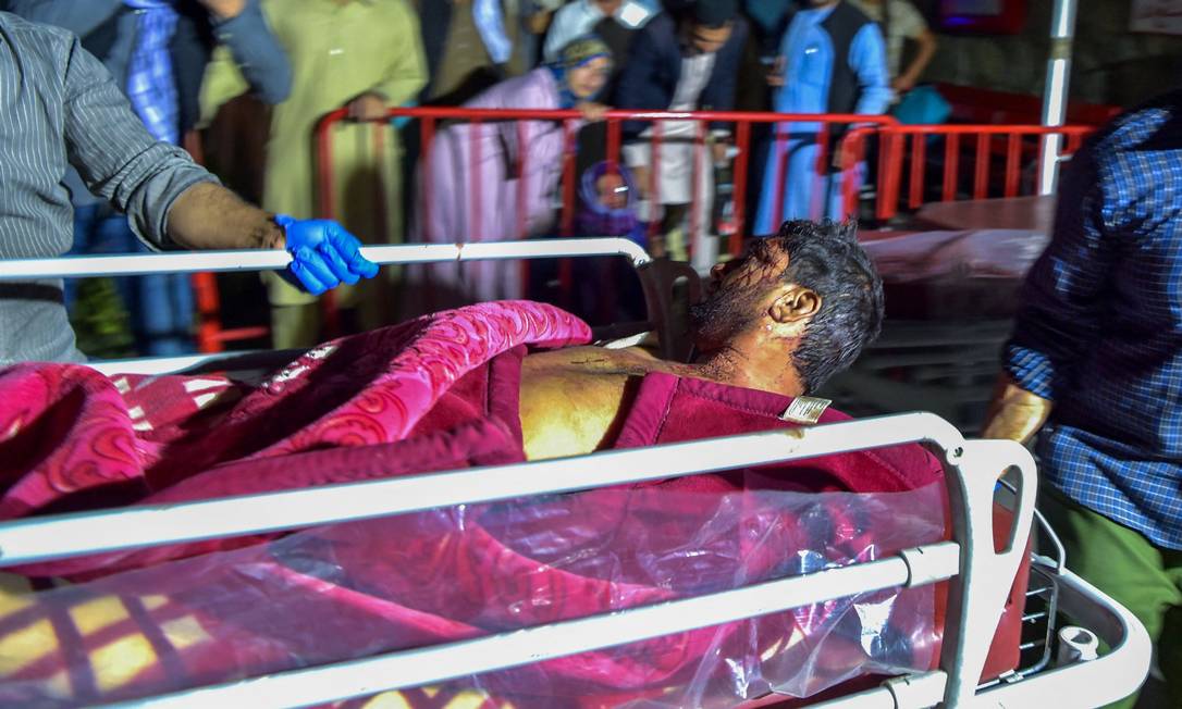 Equipe médica resgata homem ferido pelas explosões no aeroporto de Cabul Foto: WAKIL KOHSAR / AFP
