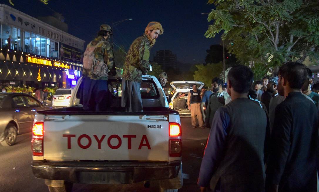 Talibãs fazem guarda no aeroporto de Cabul enquanto voluntários trabalham atendento vítimas do atentado Foto: WAKIL KOHSAR / AFP