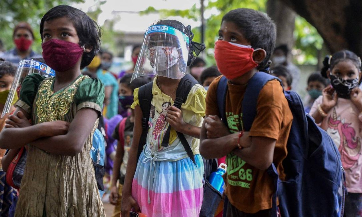 Alunos, usando EPI contra o coronavírus, retornam as aulas presenciais em escola do governo em Hyderabad, na Índia Foto: NOAH SEELAM / AFP