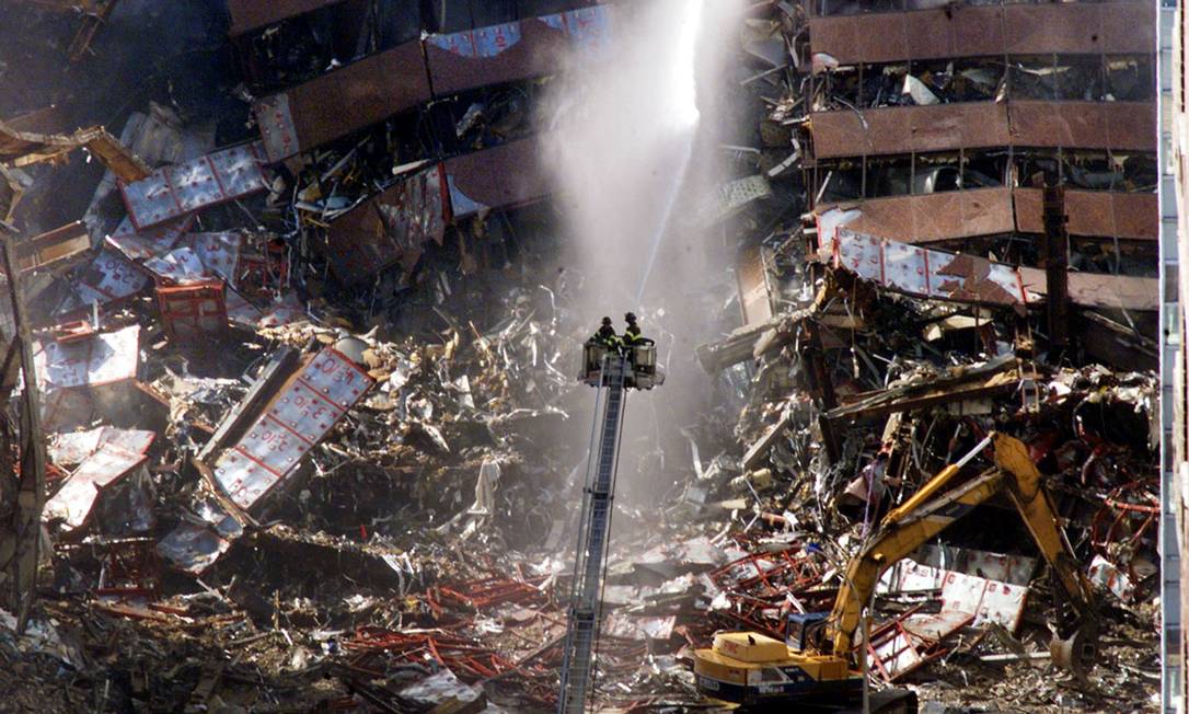 Bombeiros despejam água nos destroços do World Trade Center, no dia seguinte ao atentado Foto: Mike Segar / Reuters