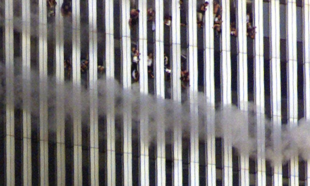 Pessoas são vistas nas janelas da torre Norte em chamas Foto: Jeff Christensen / Reuters