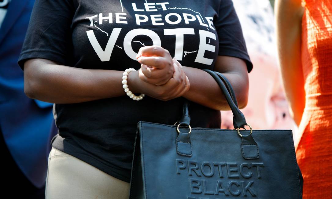 Deputada estadual Jasmine Crockett participa de coletiva com colegas democratas; 'Deixem o povo votar', diz a blusa da parlamentar, enquanto sua bolsa carrega a frase 'protejam a população negra' Foto: GABRIELLE CROCKETT / REUTERS