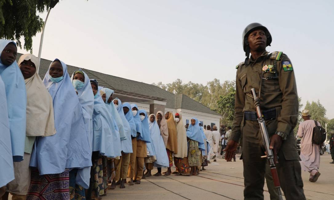 Um grupo de meninas recém sequestradas é vigiado por um soldado nigeriano Foto: AFP