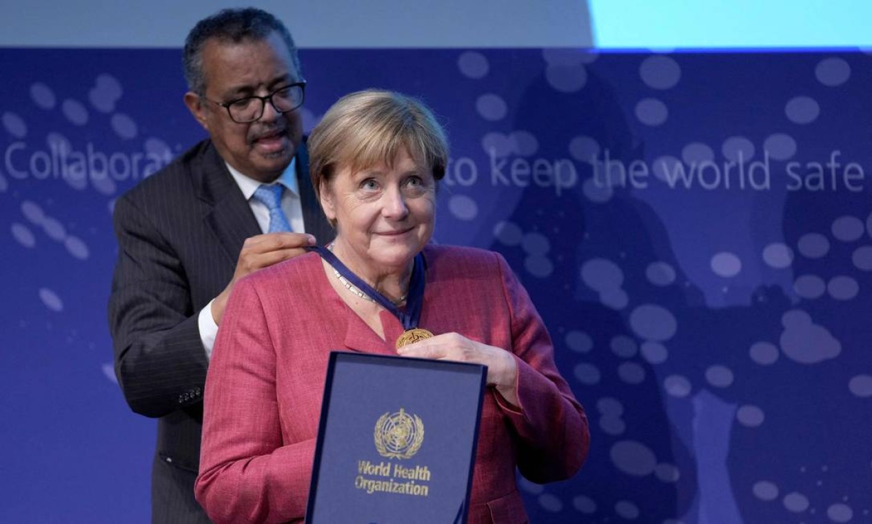 A chanceler alemã Angela Merkel recebe medalha de Tedros Adhanom Ghebreyesus, diretor-geral da Organização Mundial da Saúde (OMS), na cerimônia de inauguração do 'Centro da OMS para Inteligência Pandêmica e Epidêmica', no edifício Langenbeck-Virchow em Berlim, Alemanha Foto: MICHAEL SOHN / AFP