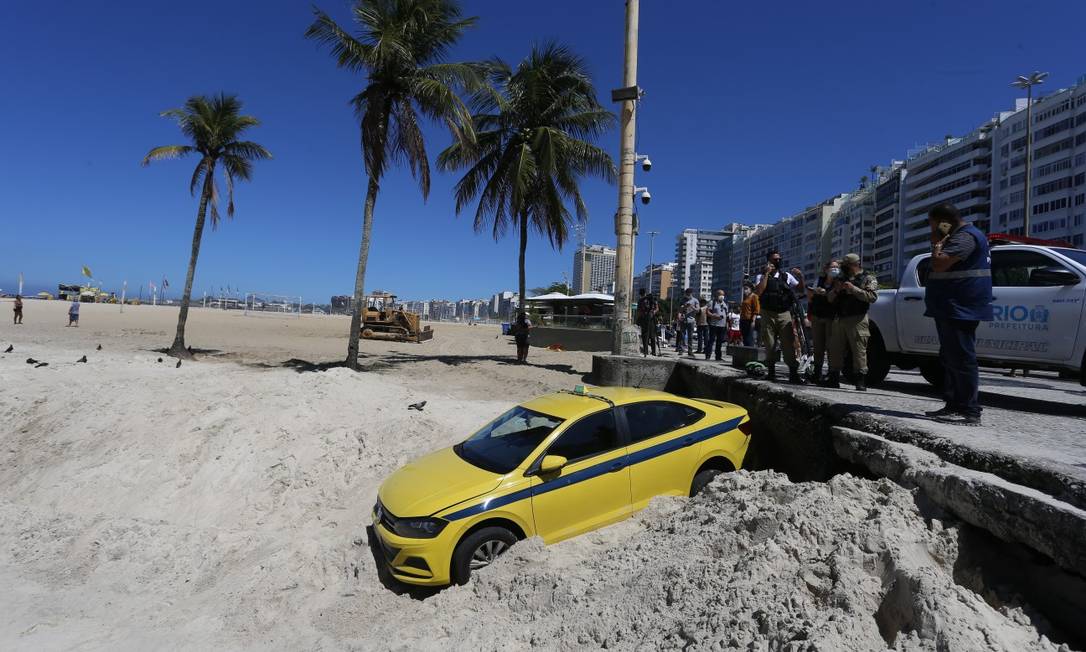 Táxi caiu na areia da Praia de Copacabana, na altura da Rua Santa Clara Foto: Fabiano Rocha / Agência O Globo