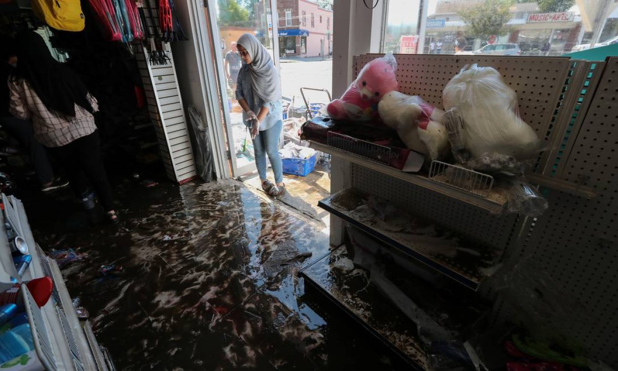 Trabalhador olha para a loja danificada pela enchente em Mamaroneck, Nova York Foto: MIKE SEGAR / REUTERS