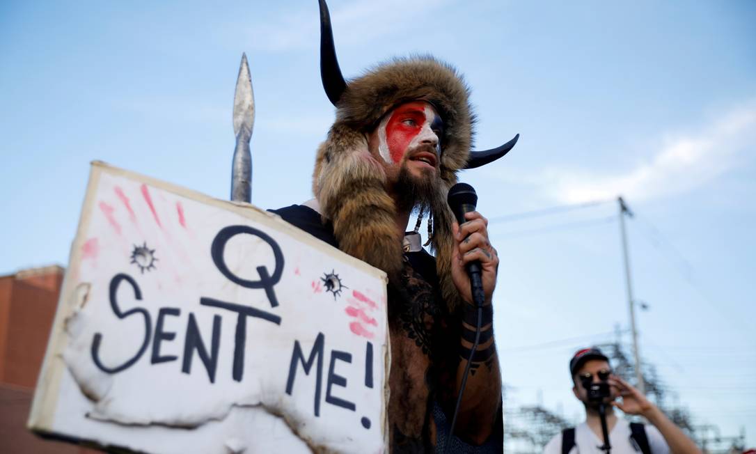 Jacob Chansley durante protesto pró-Trump em novembro de 2020, no qual segurava um cartaz em referência à teoria da conspiração QAnon Foto: Cheney Orr / REUTERS