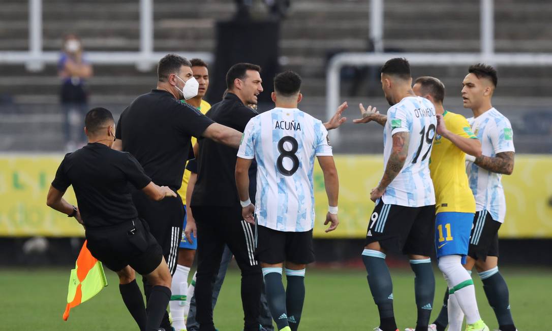 O técnico da Argentina, Lionel Scaloni, e equipe de arbitragem enquanto o jogo é interrompido por autoridades de saúde brasileiras Foto: AMANDA PEROBELLI / REUTERS