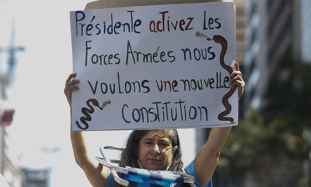 &#034;Presidente, ative as forças armadas, queremos uma nova Constituição&#034;, diz cartaz, em francês, de manifestante na Avenida Paulista, em São Paulo Foto: MIGUEL SCHINCARIOL / AFP