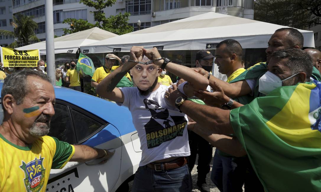 Em Copacabana manifestantes, usando um carro da Polícia Militar, encenam a prisão do ministro Alexandre de Moraes, relator do inquérito que investiga atos antidemocráticos Foto: Gabriel de Paiva / Agência O Globo