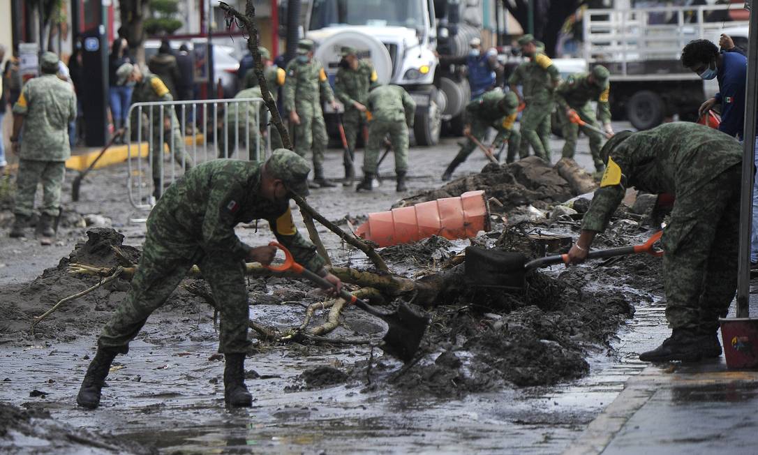 Membros do Exército Mexicano removem lama das ruas após fortes chuvas que causaram inundações em Encatepec, México Foto: CLAUDIO CRUZ / AFP