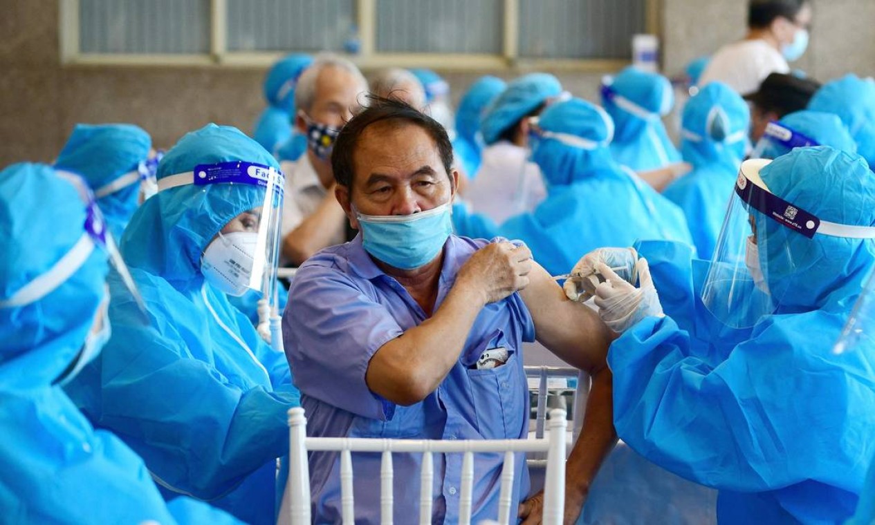 Homem recebe vacina contra Covid-19 em Hanói, Vietnã Foto: NHAC NGUYEN / AFP