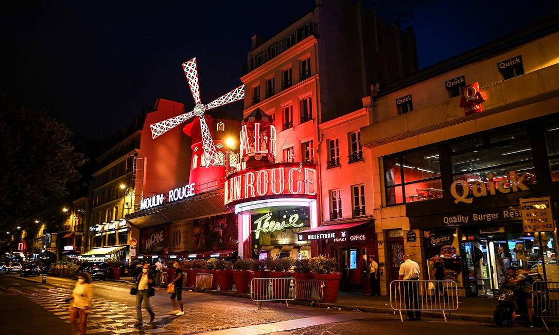 O moinho vermelho do Moulin Rouge é um verdadeiro cartão-postal na boêmia região de Montmartre, em Paris Foto: CHRISTOPHE ARCHAMBAULT / AFP