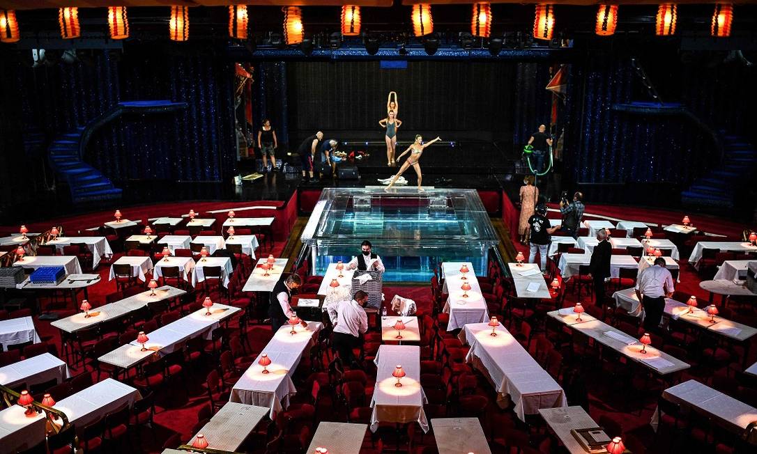 Garçons preparam o salão do Moulin Rouge, antes da reabertura, em 10 de setembro Foto: CHRISTOPHE ARCHAMBAULT / AFP