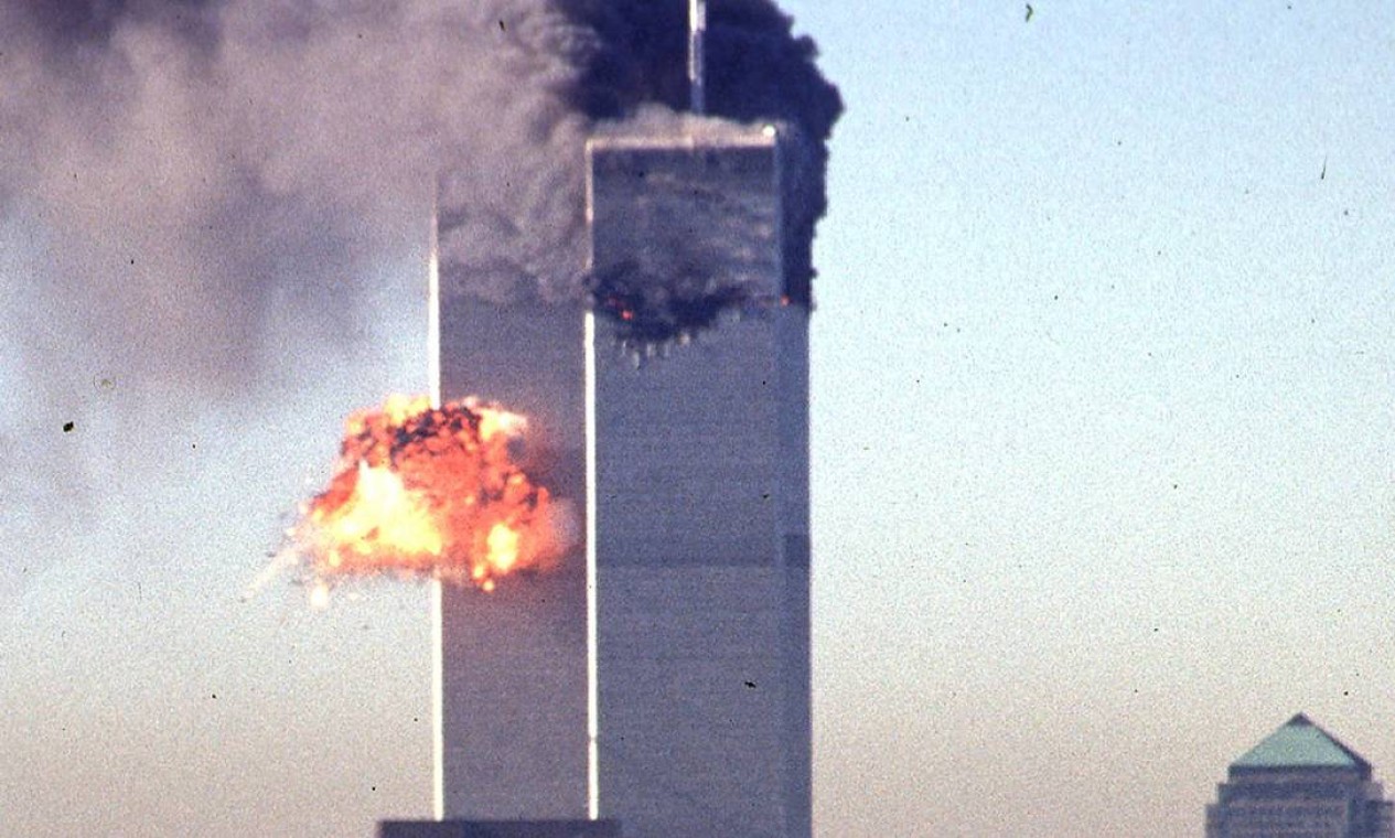 Fumaça e chamas irrompem das torres gêmeas do World Trade Center depois que dois aviões sequestrados alvejaram o símbolo de poder econômico da ilha de Manhattan, Nova York Foto: SETH MCALLISTER / AFP