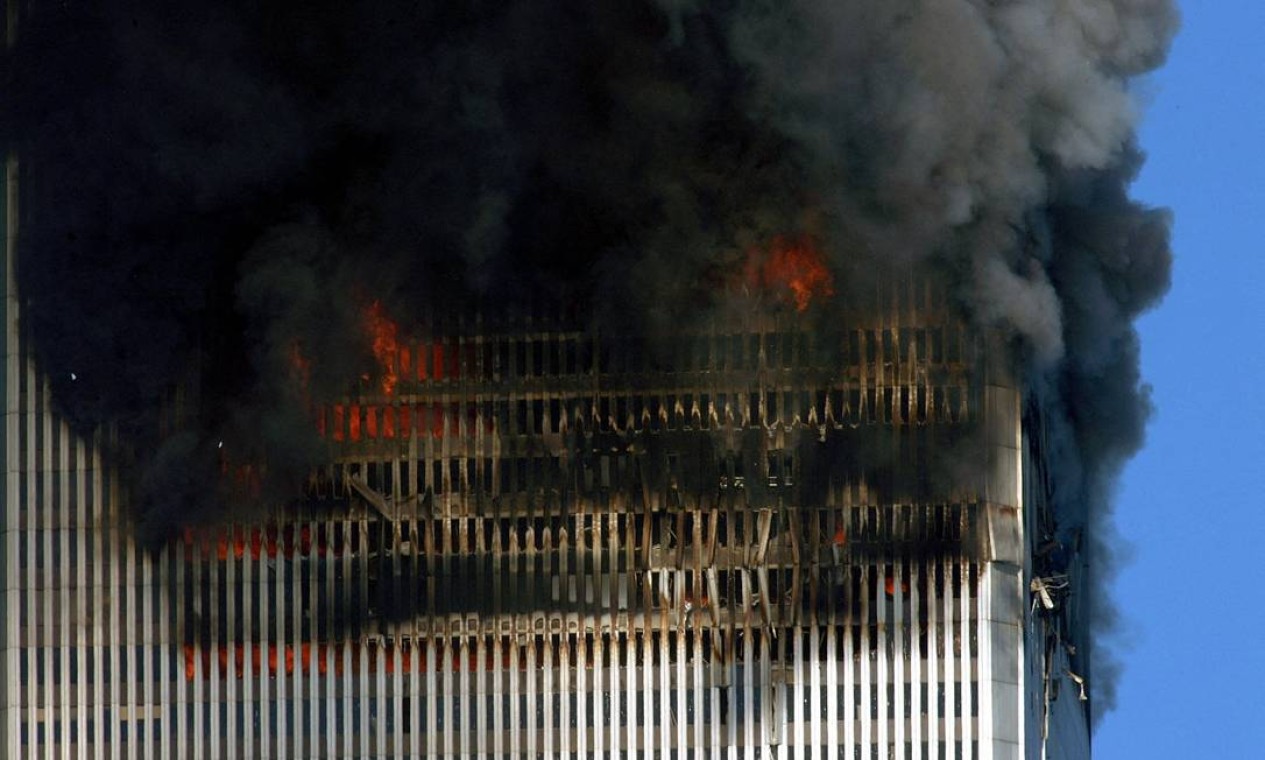 Fumaça e chamas saem das torres gêmeas do World Trade Center antes de seu colapso em Manhattan, Nova York Foto: HENNY RAY ABRAMS / AFP