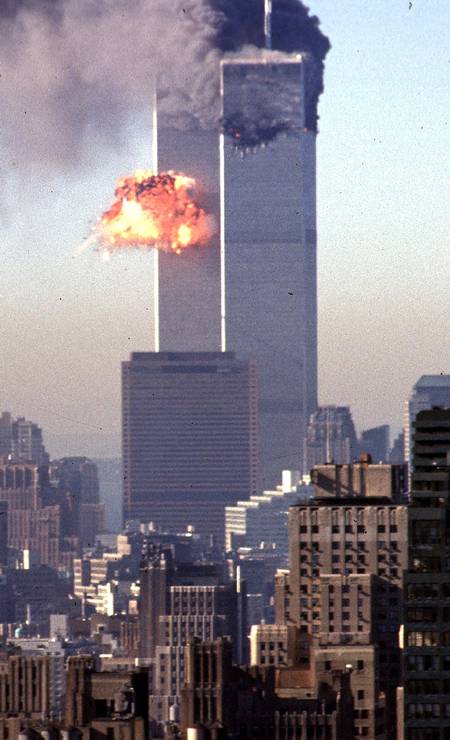 Fumaça e chamas irrompem das torres gêmeas do World Trade Center depois que dois aviões sequestrados alvejaram o símbolo de poder econômico da ilha de Manhattan, Nova York Foto: SETH MCALLISTER / AFP
