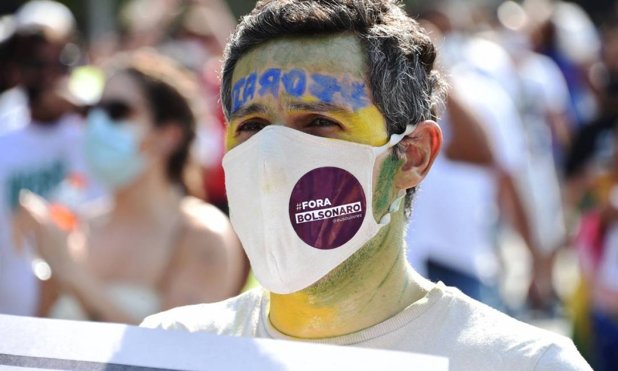 Manifestante, usando máscara de proteção e a cara pintada de verde e amarelo, protesta pelo impeachment de Bolsonaro em Brasília Foto: EVARISTO SA / AFP