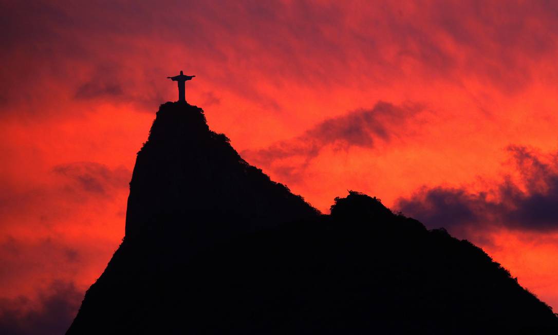 Silhueta do Corcovado, com o Cristo Redentor no topo. é vista em contraste com céu avermelhado de um pôr do sol em 2009 Foto: Custódio Coimbra / Agência O Globo