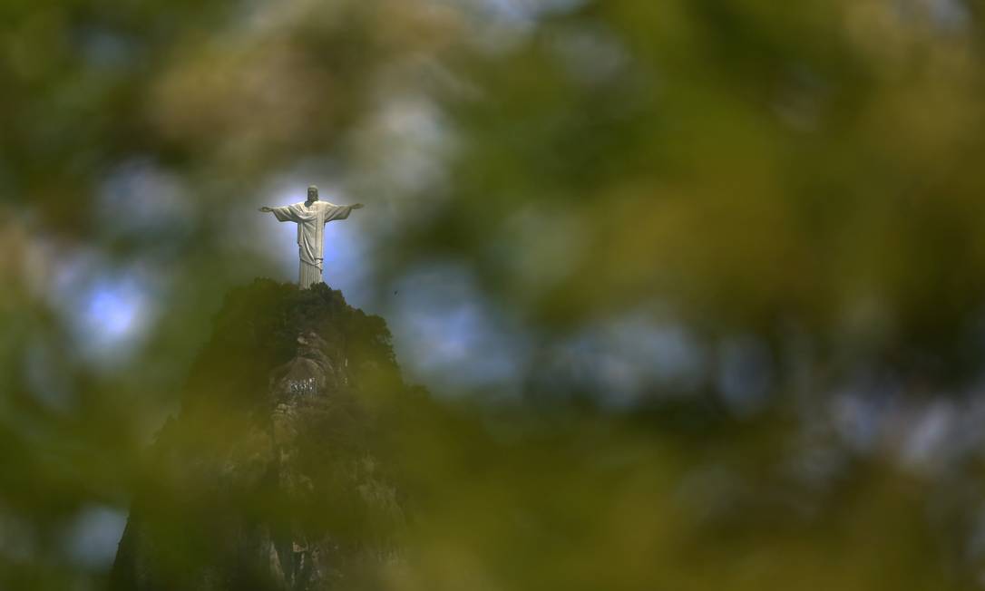 Estátua do Cristo é vista entre folhagem de árvore Foto: Custódio Coimbra / Agência O Globo