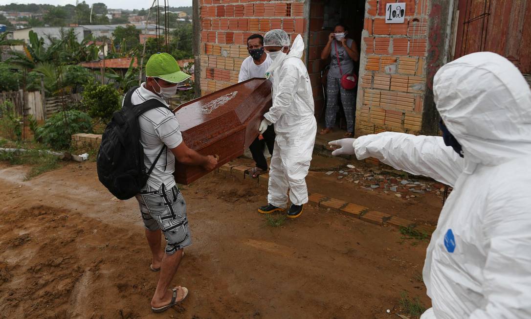 Agentes funerários removem caixão de idoso morto pela Covid-19, em Manaus, Amazonas, em maio de 2020. Foto: MICHAEL DANTAS / AFP