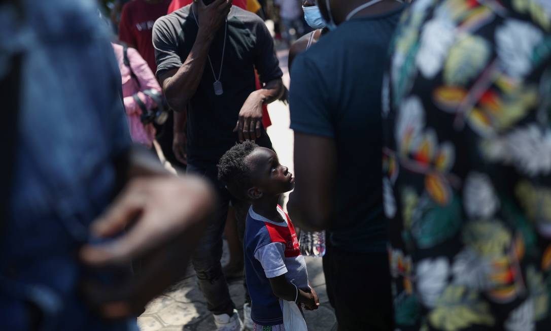 Criança haitiana junto a grupo de imigrantes que aguardam para entregar documentos a representantes de organizações sociais para regularizar sua situação de imigração na praça Benito Juarez, em Tapachula, no estado de Chiapas, México Foto: EDGARD GARRIDO / REUTERS - 14/09/2021