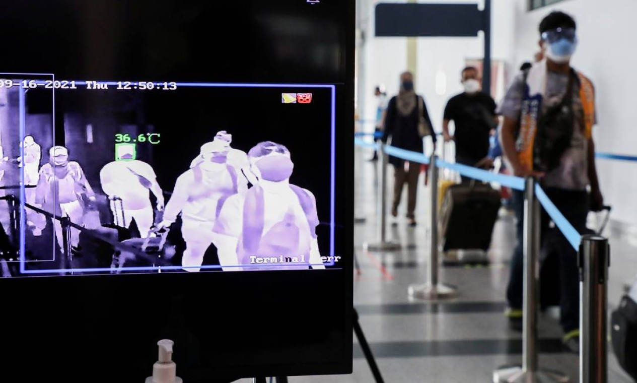 Turistas passam por scaner térmico para poderem embarcar em voos domésticos na Malásia Foto: LIM HUEY TENG / REUTERS
