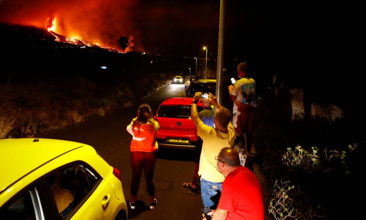 Moradores assistem a lava jorrar após a erupção do vulcão Cumbre Vieja, em El Paso Foto: BORJA SUAREZ / REUTERS