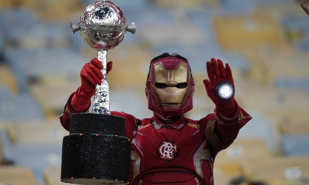 Torcedor fantasiado de Homem de Ferro rubro-negro segura réplica da taça Libertadores Foto: SILVIA IZQUIERDO / Pool via REUTERS