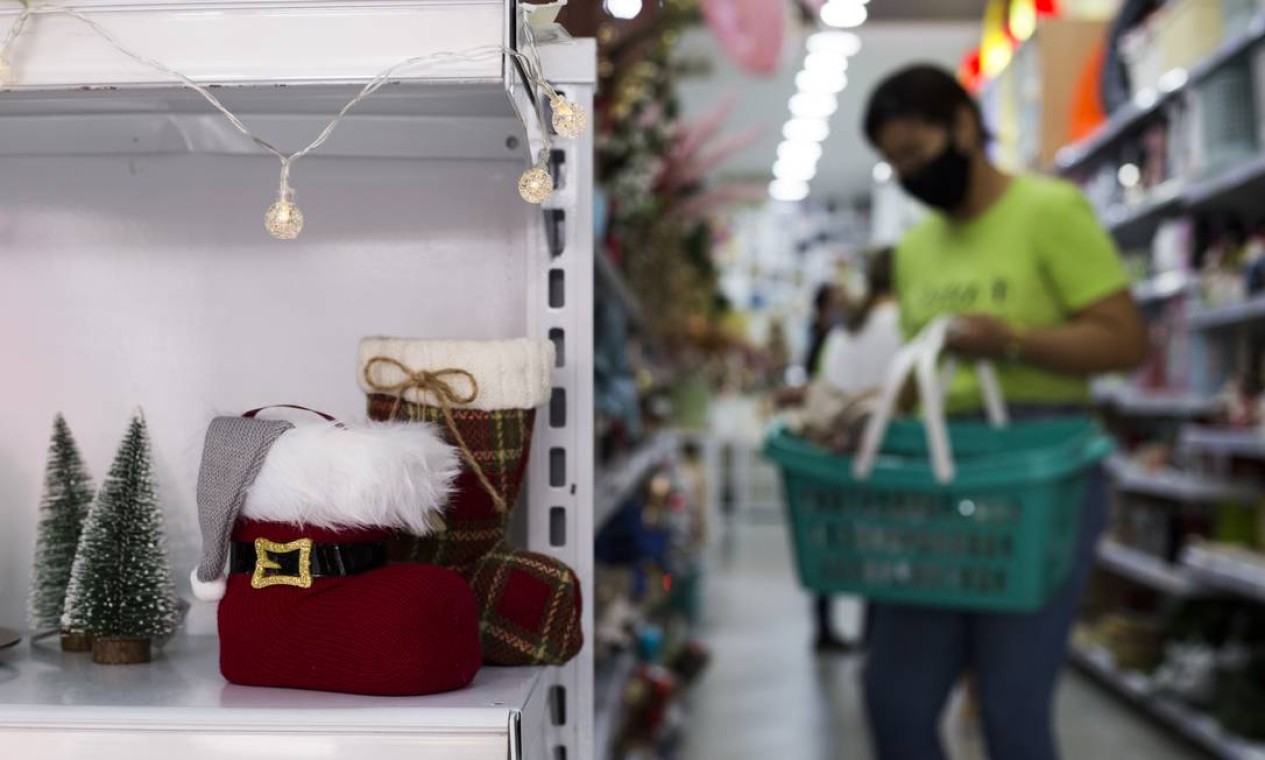 Funcionário organiza produtos natalinos em prateleira de loja no Saara Foto: Maria Isabel Oliveira / Agência O Globo