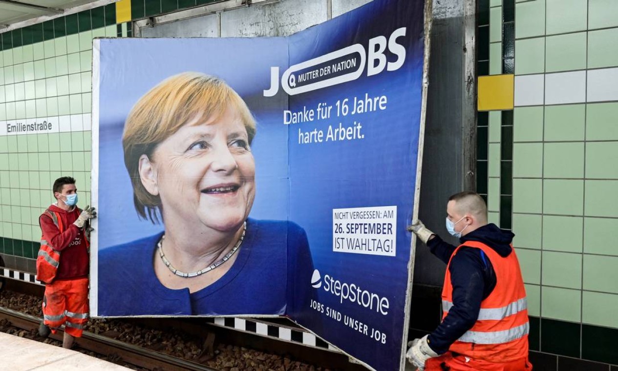 Trabalhadores removem anúncio que mostra a chanceler alemã Angela Merkel com um slogan que diz "Mãe da Nação - Obrigado por 16 anos de trabalho árduo" antes das próximas eleições estaduais em Hamburgo, Alemanha Foto: FABIAN BIMMER / REUTERS - 24/09/2021