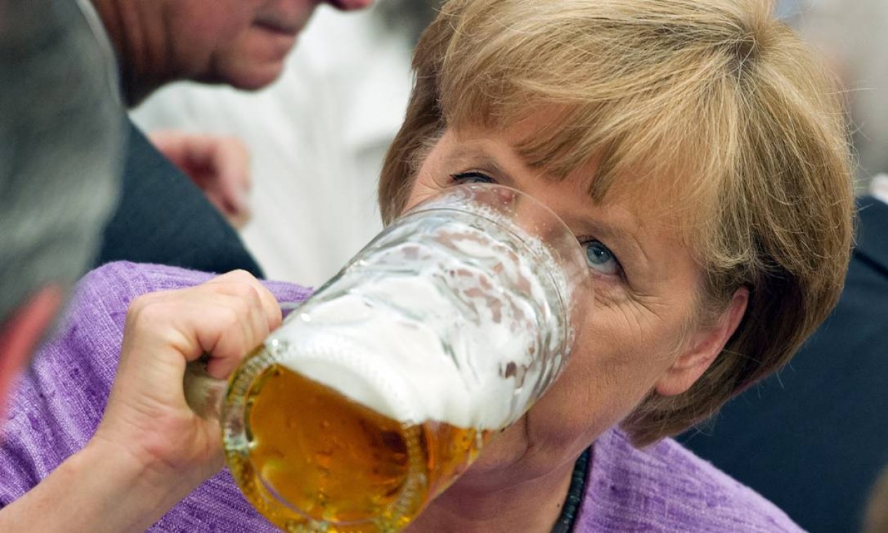 Angela Merkel bebe cerveja enquanto participa do evento "político matinal" na feira Gillamoos em Abensberg, sul da Alemanha Foto: PETER KNEFFEL / AFP - 03/09/20121