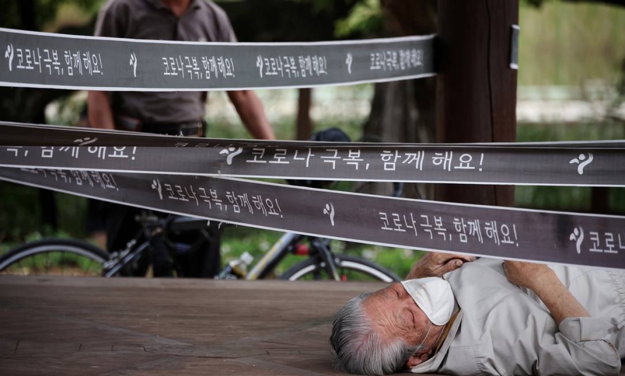 Homem repousa em um pavilhão que foi isolado como uma medida para evitar a propagação da COVID-19, em um parque em Seul, Coreia do Sul Foto: KIM HONG-JI / REUTERS