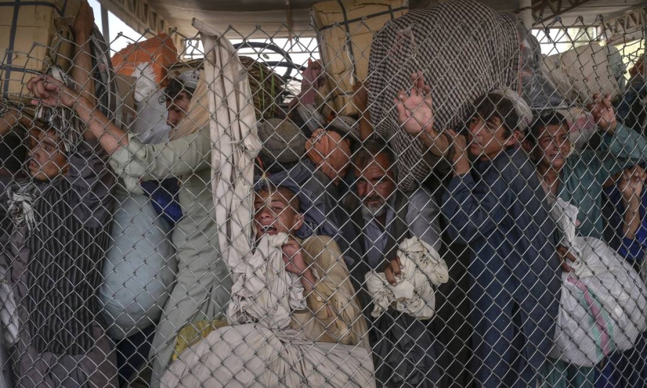 Pessoas correm para passar pelo portão da fronteira com o Paquistão a partir da fronteira com o Afeganistão em Spin Boldak. Milhares de afegãos tentam escapar da miséria e migram para a fronteira sul de seu país, mas tentativas de atravessar são frustradas pelo Talibã Foto: BULENT KILIC / AFP