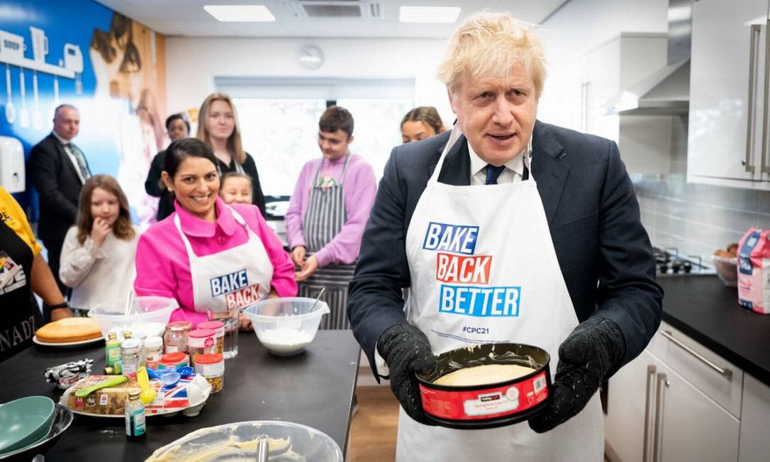 Premier do Reino Unido, Boris Johnson, ajudou a assar um bolo durante evento paralelo à conferência do Partido Conservador Foto: STEFAN ROUSSEAU / AFP