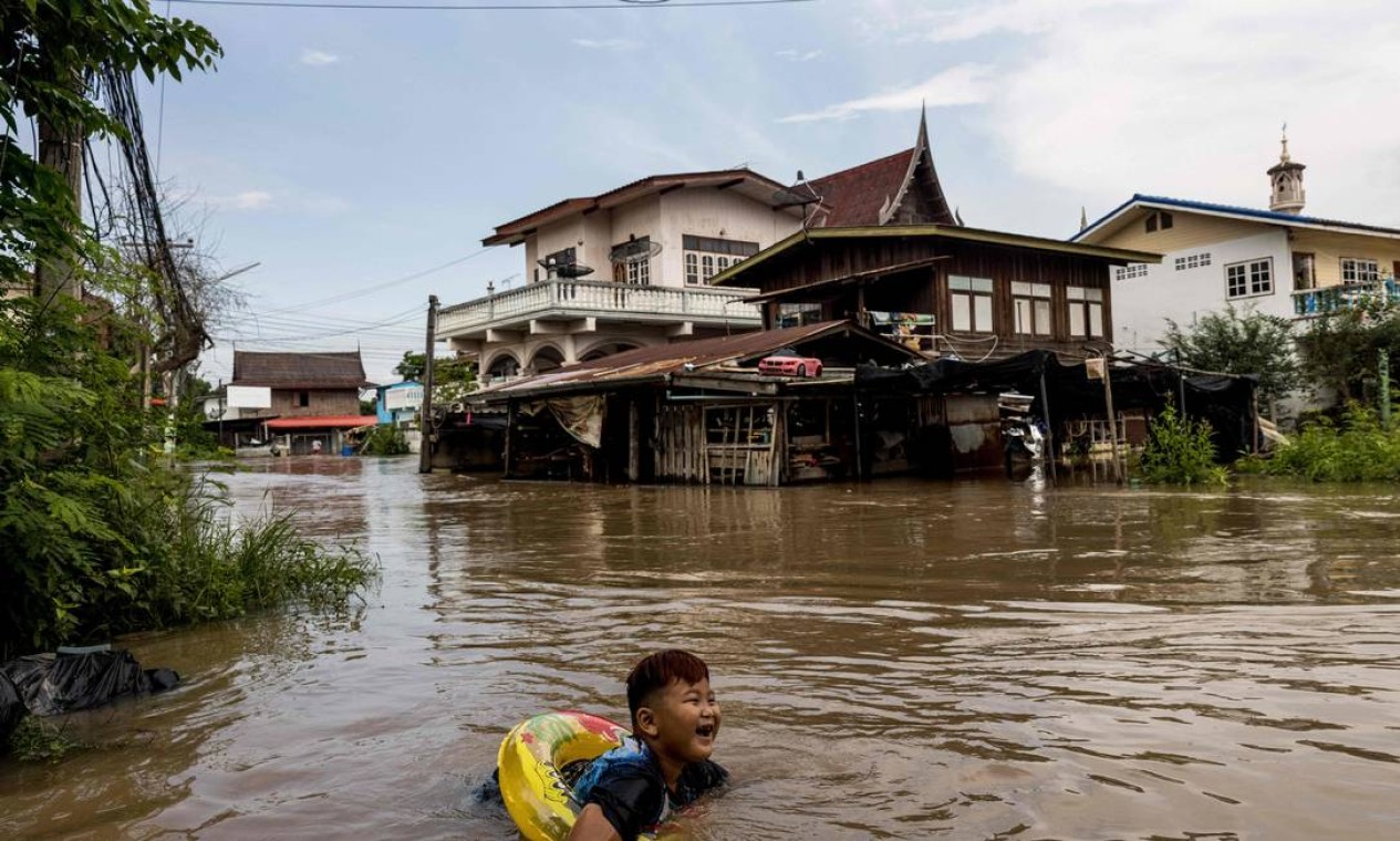 Menino usa uma boia para brincar nas enchentes de Ayutthaya, bairro da Tailândia atingido pela tempestade tropical Dianmu Foto: JACK TAYLOR / AFP