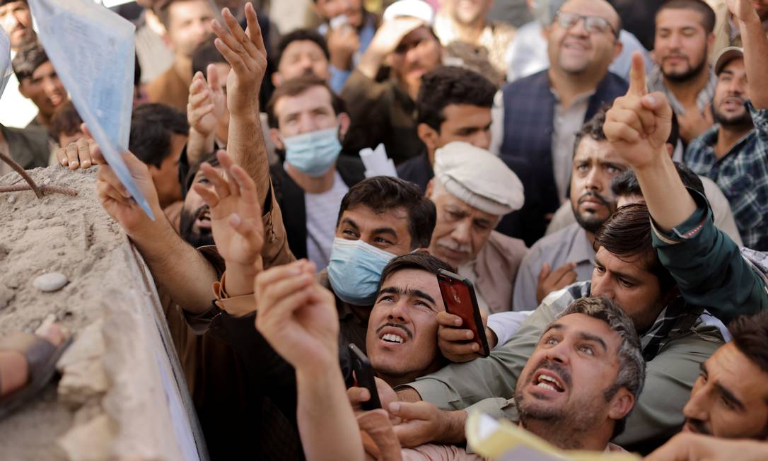 Afegãos se reúnem do lado de fora do escritório de passaportes depois que funcionários do Talibã anunciaram que retomarão os serviços Foto: JORGE SILVA / REUTERS
