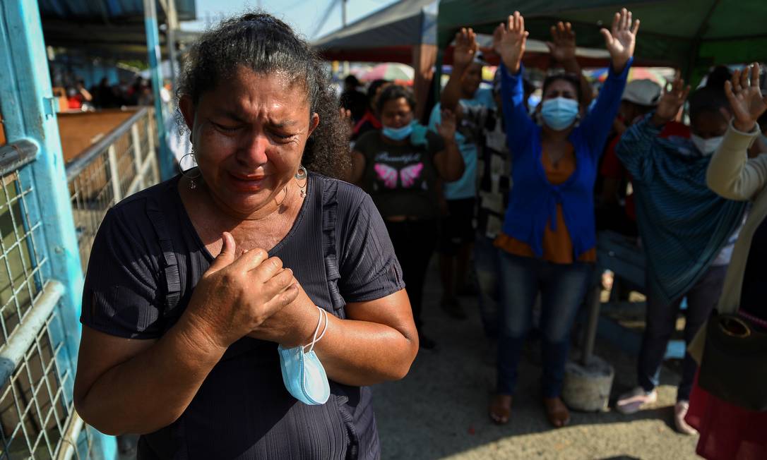 Familiares rezam do lado de fora da Penitenciaria del Litoral, onde eclodiu um motim que deixou mais de 100 mortos em Guayaquil, no Equador, na semana passada Foto: VICENTE GAIBOR DEL PINO / REUTERS