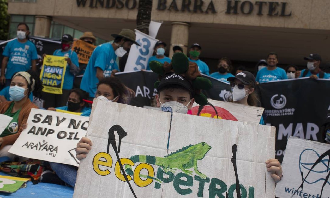 Manifestante segura cartaz com logo de petrolífera colombiana Foto: Marcia Foletto / Agência O Globo