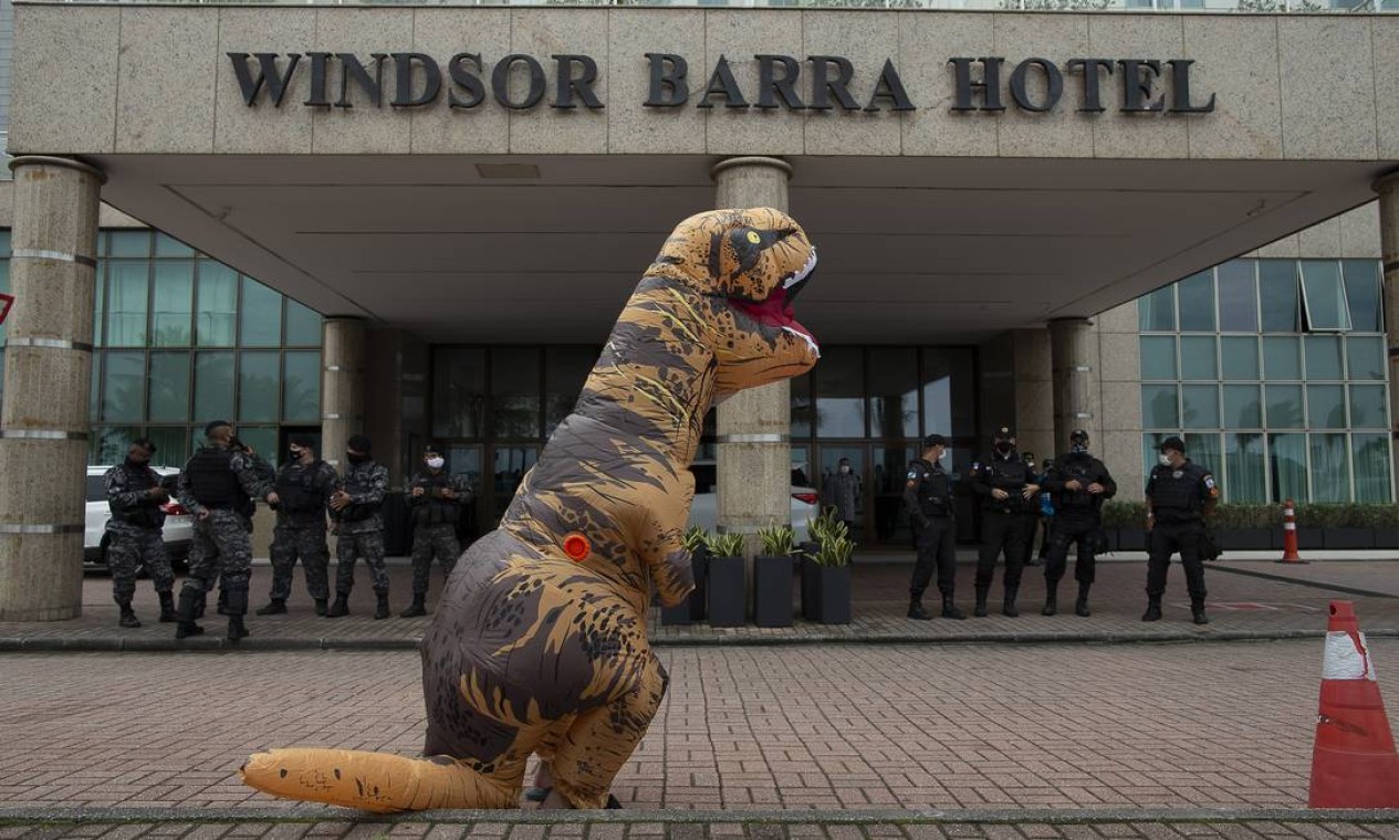 Manifestante vestido de tiranossauro rex protesta, em frente a hotel na Barra da Tijuca contra leilão da ANP Foto: Marcia Foletto / Agência O Globo