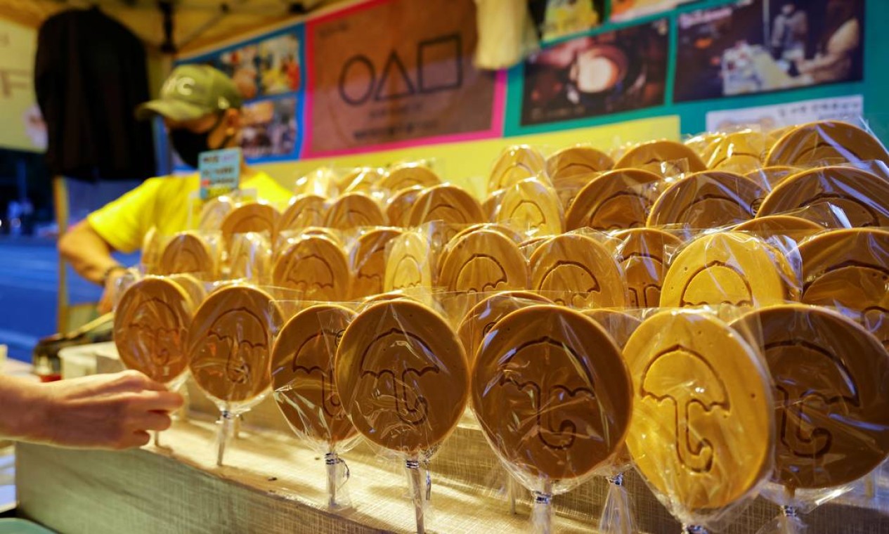 Barraca de doces em Seuol, capital da Coreia do Sul, exibe dalgonas com desenhos iguais ao do doce que aparece na série 'Round 6' Foto: HEO RAN / REUTERS