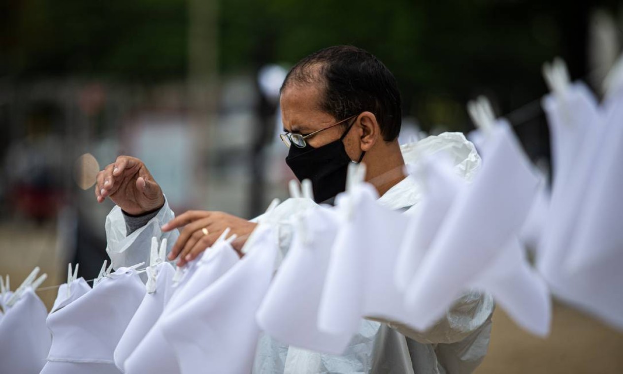 Ativista prega lenços brancos em varal para simbolizar as vítimas da pandemia no Brasil Foto: Hermes de Paula / Agência O Globo